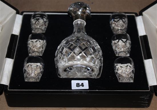 A Mappin & Webb silver mounted cut glass liqueur decanter and four tots,